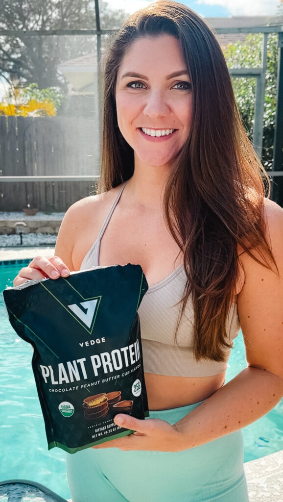 myplantbasedfriend holding edge protein powder